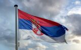 Serbia flag waving against cloudy sky