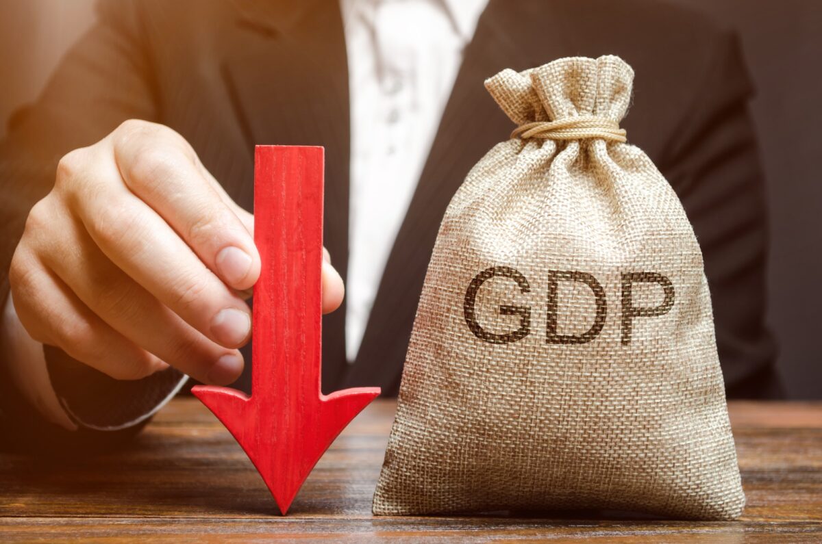 A bag with the word GDP and a down arrow in the hands of a businessman
