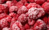 Frozen red raspberry all over background,close up