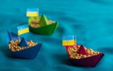 Boats with Ukrainian soybeans made of paper origami concept