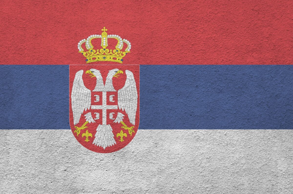 Serbia flag depicted in bright paint colors on old relief plastering wall close up
