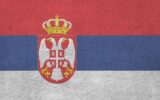 Serbia flag depicted in bright paint colors on old relief plastering wall close up