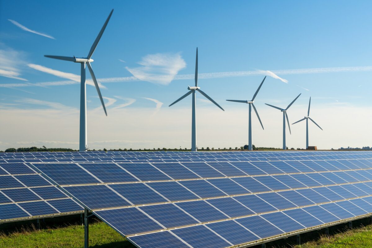 Wind turbine energy generaters on wind farm, with solar panels underneath.