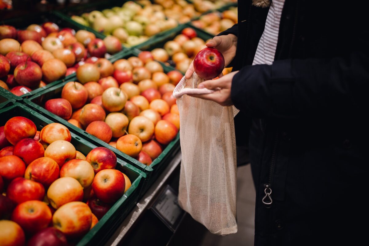 Closeup shot of a female buying sweet apples in the market
